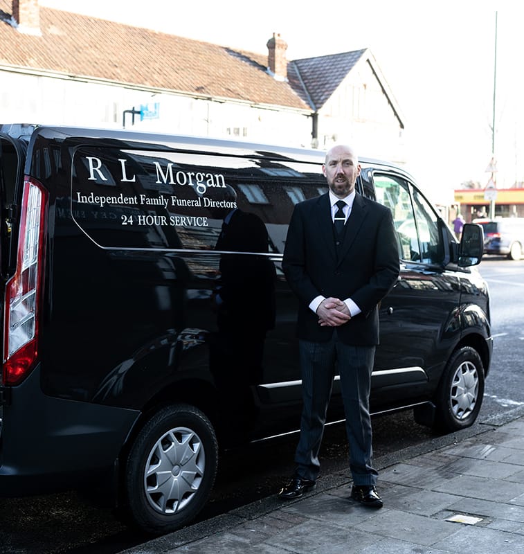 black and white photo of rl morgan hearse and man next to it